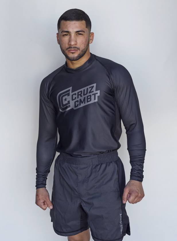 Man wearing a black long-sleeve shirt and shorts with 'Cruz Combat' logo on a white background